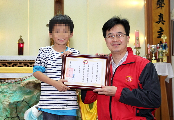 圣方济育幼院的小朋友代表致赠感谢状予王育文董事长（右）， 两人开心合影 - 