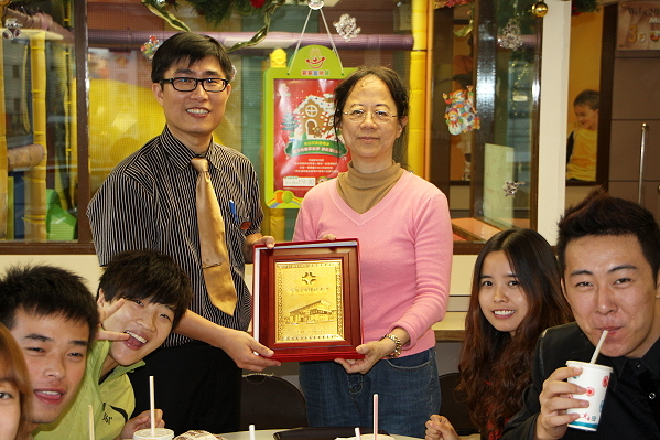 陸春霖老師(後排右)代表本校致贈紀念品予許文收經理（後排左） - 