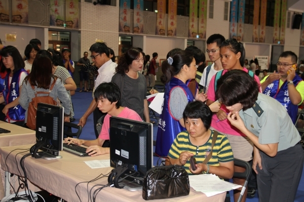 不少新生在註冊當天搶著登記申請學校宿舍，本校工作人員在一旁協助操作 - 