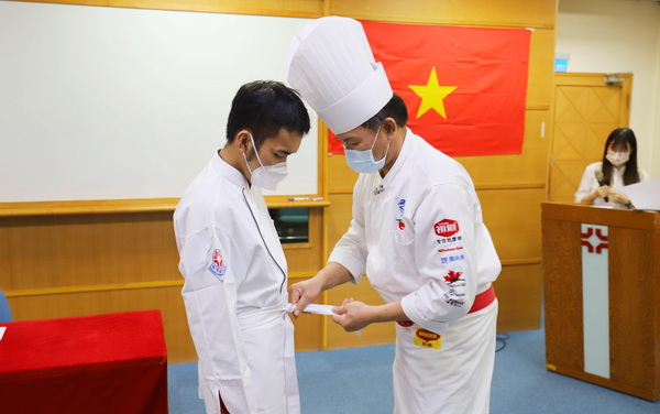 3-1.导师黄家洋老师(图右)协助黄黎清辉同学(图左)穿上厨服
