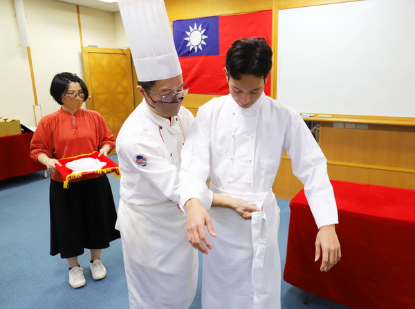 4-1.导师陈庆麟老师(图左)协助阮英俊同学(图右)穿上厨服