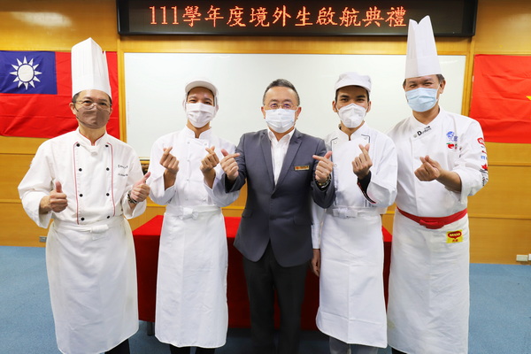 5-1.校长黄荣鹏颁发厨服给2个班级的新生代表，并由导师黄家洋老师及陈庆麟老师协助同学穿上厨服后合照