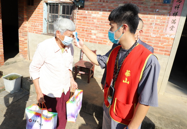 5-1.華山基金會站長張墾棠為獨居的謝高奶奶量體溫