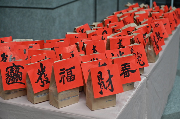 8-1.今年最特别之处，是在团拜结束之后，参与同仁每人抢着领取一份，通识教育中心主任暨广秀书弈学苑执行长姜明翰老师亲手书写完成的新春喜字